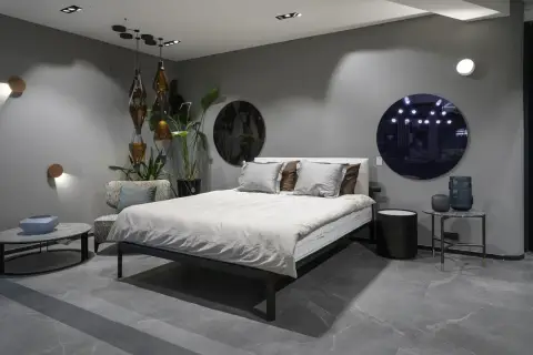 Nowoczesna sypialnia z kinkietami, łóżkiem i designerskimi dodatkami.