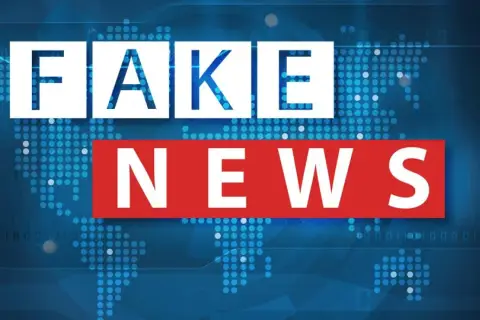 Napis "FAKE NEWS" na tle mapy świata z cyfrowym wzorem. Uważaj na dezinformację!