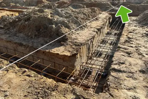 Wytyczenie budynku: zbrojenie ławy fundamentowej w wykopie. Widać sznur geodezyjny do precyzyjnego wyznaczenia.