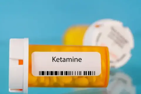 Lek ketamina co to? Pomarańczowa buteleczka z tabletkami i etykietą "Ketamine".