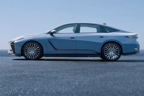Nowy Lexus ES w błękitnym kolorze, prezentujący swoją elegancką sylwetkę na tle błękitnego nieba i morza.