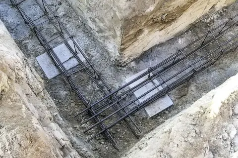 Gotowe zbrojenie fundamentu w wykopie. Stalowe pręty tworzą solidną konstrukcję, gotową na zalanie betonem.
