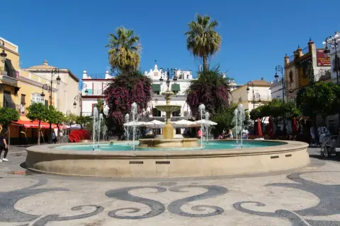 Plaza con fuente y palmeras. Un buen punto de partida para saber cómo llegar a Sanlúcar de Barrameda.