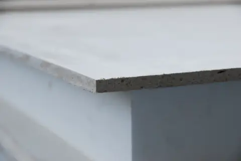 Szara płyta mgo, widoczna z boku, z widoczną teksturą materiału.