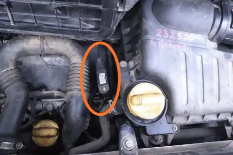 Czujnik ciśnienia doładowania w silniku Renault, zaznaczony pomarańczowym owalem.