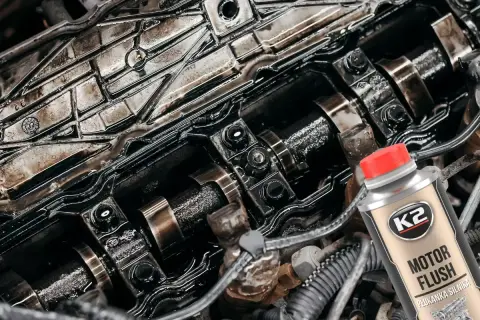 Wnętrze silnika po płukaniu ropą. Widać zabrudzone elementy i butelkę preparatu K2 Motor Flush.