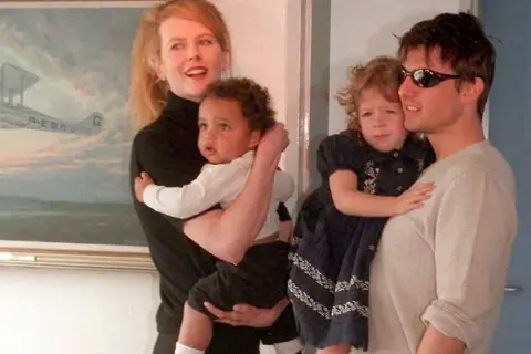 Nicole Kidman i Tom Cruise z dwójką dzieci. W tle obraz z samolotem.