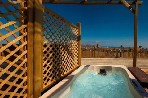 Jacuzzi burbujeante en un balcón con vistas al mar, parte de la experiencia mágica en Natura Resort.