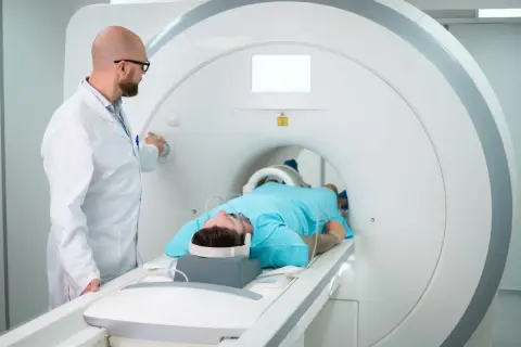 Lekarz przygotowuje pacjenta do badania rezonansem magnetycznym. Pacjent leży w aparacie, gotowy na test apleya.
