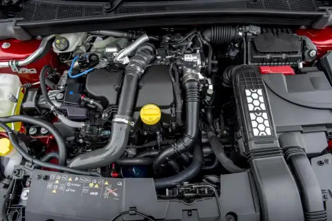Silnik 1.5 dCi w samochodzie, z widocznymi elementami układu dolotowego i turbosprężarki.