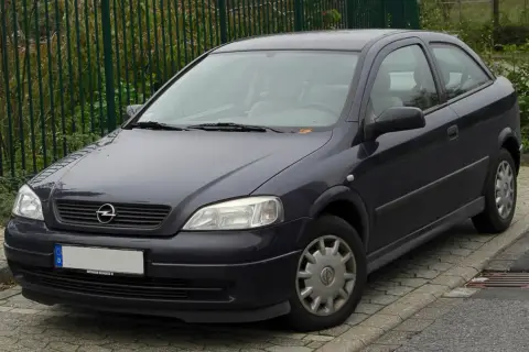 Ciemnoszary Opel Astra G 1.6 16v stoi na chodniku.