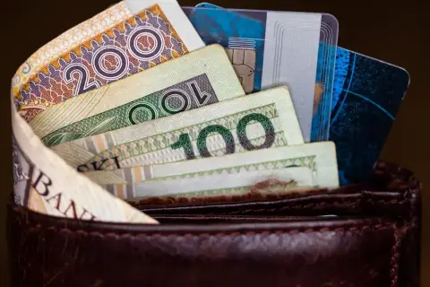 Portfel z polskimi banknotami (200 zł, 100 zł) i kartami płatniczymi.