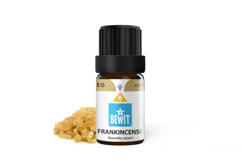 Butelka olejku eterycznego z kadzidłowcem (frankincense) obok żywicy. Elemi, czyli kadzidłowiec, to cenny składnik.