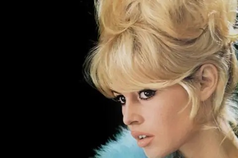 Icono de los moda peinados de los 60 con cabello rubio voluminoso y maquillaje dramático.