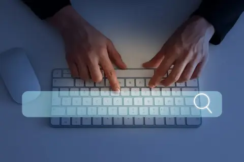 Ręce wpisują w wyszukiwarkę "jak sprawdzić swój NIP". Obok klawiatury leży myszka.