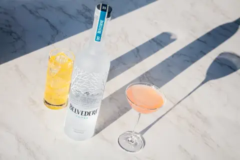 Wódka Belvedere 0.7 cena: elegancka butelka, drink w kieliszku i szklanka z lodem na marmurowym blacie.