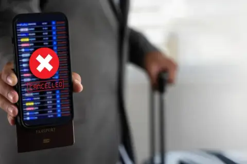 Telefon z napisem "CANCELLED" i czerwonym krzyżykiem, pod nim paszport. Podróż z Ryanair zwrot biletu stał się niemożliwy.