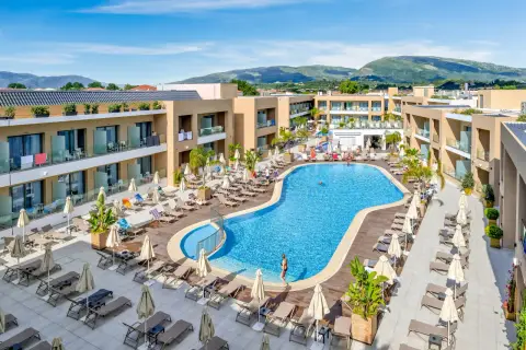 Luksusowy hotel White Olive Elite w Laganas, Grecja. Basen, leżaki i palmy tworzą idealne miejsce na relaks.