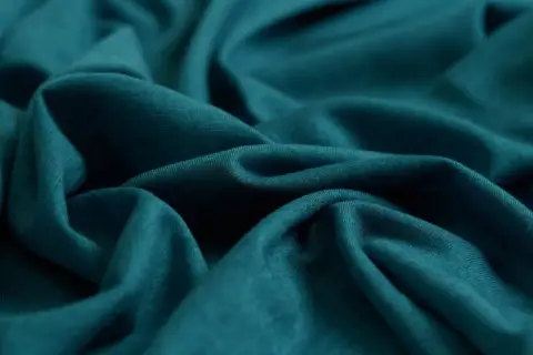 Tela de lyocell con pliegues profundos, mostrando su caída suave. A pesar de sus ventajas, hay desventajas del lyocell a considerar.