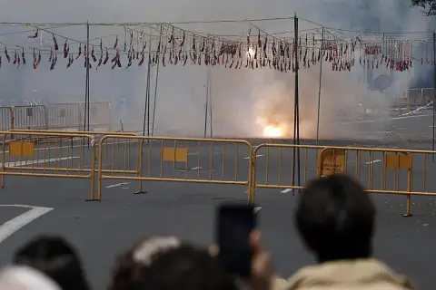 El estruendo de la mascletà hoy llena el aire de humo y chispas. Cuerdas de petardos cuelgan, esperando el momento de explotar.