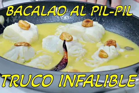 Bacalao al pil pil en sartén, con trozos de pescado blanco, ajos dorados y una guindilla. ¡La receta infalible!
