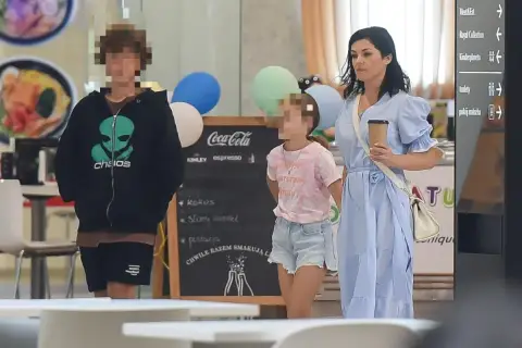 Kobieta w niebieskiej sukience z dwójką dzieci w centrum handlowym.
