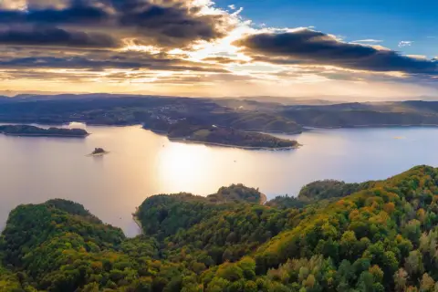 Zachód słońca nad jeziorem Solina. Widać zalesione wzgórza, wyspy i zatoczki. Idealne miejsce na odkrywanie atrakcji Solina i okolice.