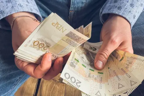 Dłonie liczą banknoty 200 zł. To może być oszczędność na emeryturę z KRUS.