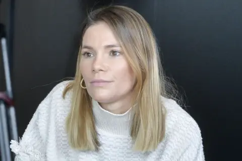 Maja Bohosiewicz w swetrze z golfem i złotymi kolczykami, zamyślona.