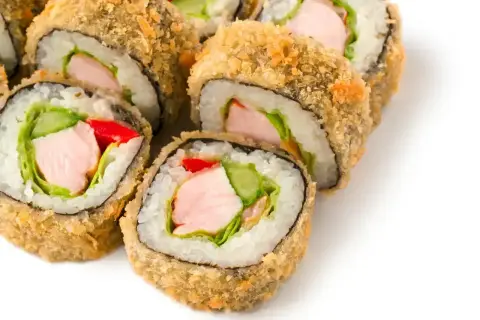 Usmażone rolki sushi z kurczakiem, ogórkiem, czerwoną papryką i sałatą.