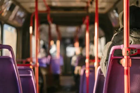 Wnętrze autobusu relacji Sanok-Wetlina. Fioletowe siedzenia i czerwone poręcze tworzą charakterystyczny widok.