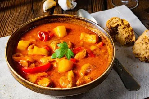 A miseczka parującej zupy gulaszowej, pachnącej jak zupa gulaszowa przepis babci. Ziemniaki, papryka i mięso w aromatycznym sosie.