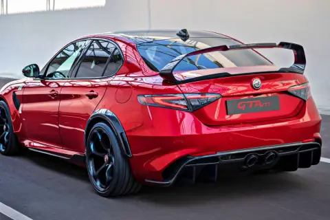 Czerwone Alfa Romeo Giulia GTAm z masywnym spoilerem i dyfuzorem, gotowe do wyścigu.