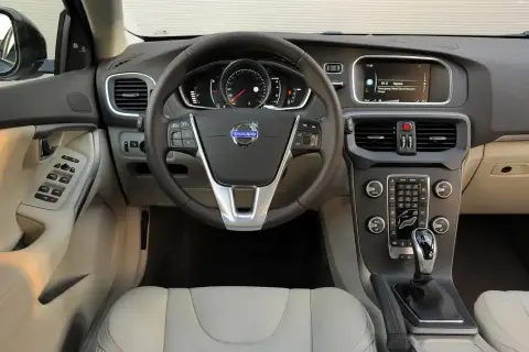 Wnętrze Volvo V40, które wielu kierowców chwali w swoich **volvo v40 opinie**. Widoczna kierownica, deska rozdzielcza z ekranem i konsola środkowa.