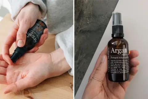 En hand applicerar arganolja för hudvård. Flaskan med ekologisk kallpressad arganolja syns också.