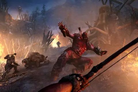 Krwawa walka w świecie Far Cry Primal. Wojownik z maczugą kontra szablozębny tygrys, a w tle płonące wioski i łuk.