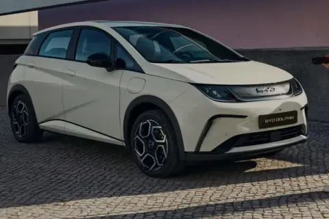 Biały BYD Dolphin, jeden z chińskich samochodów elektrycznych, gotowy do ładowania.