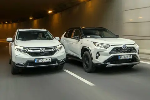Dwa białe SUV-y, Honda CR-V i Toyota RAV4, jadą tunelem.