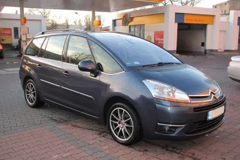 Ciemnoszary Citroen C4 Grand Picasso 2.0 HDI na tle stacji paliw.