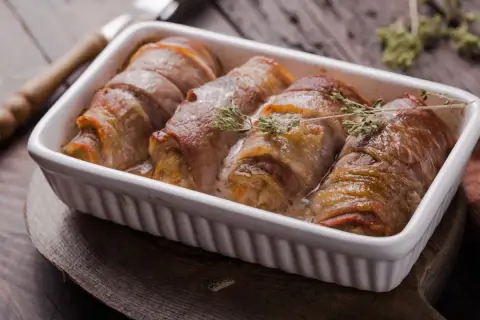 Roladki schabowe w sosie, zawinięte w boczek, wyglądają soczyście. Kluczem do sukcesu jest odpowiednie przygotowanie, by nie były suche.