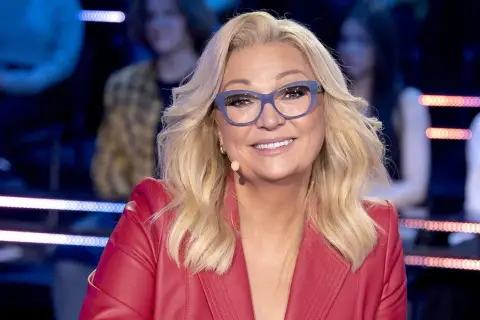 Małgorzata Walewska w czerwonej marynarce i okularach, uśmiecha się.