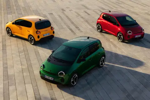 Trzy kolorowe Renault Twingo 2: zielone, żółte i czerwone, stoją na betonowej nawierzchni.