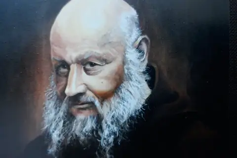 Portret starszego mężczyzny z siwą brodą i łysą głową, w ciemnej szacie.