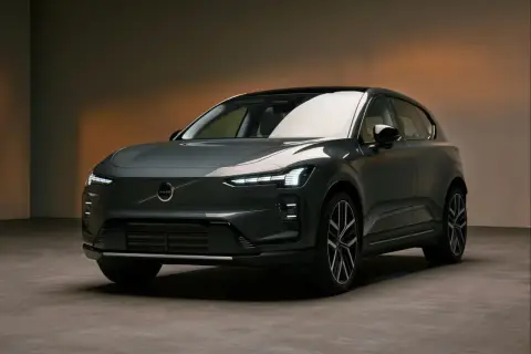 Nowoczesny, ciemnoszary Volvo EX60 z charakterystycznymi światłami LED stoi na betonowej podłodze.
