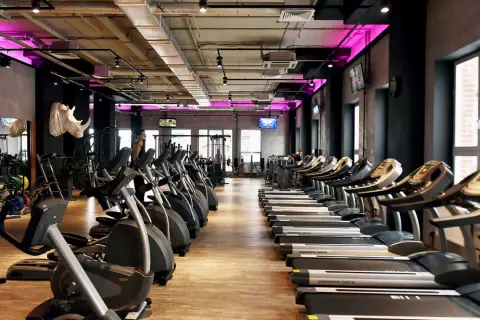 Nowoczesna siłownia z rzędami bieżni i orbitreków. Sprawdź atrakcyjną **Medicover Sport cenę** i zacznij trening!