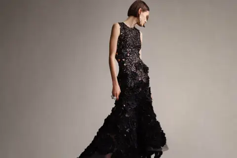 Modelka w czarnej, koronkowej sukni z falbanami, idealnej na black tie dress code damski.