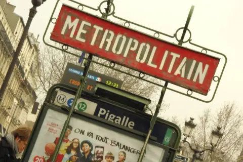 Znak stacji metra "METROPOLITAIN" w Paryżu, z widoczną nazwą stacji "Pigalle" i numerami linii.