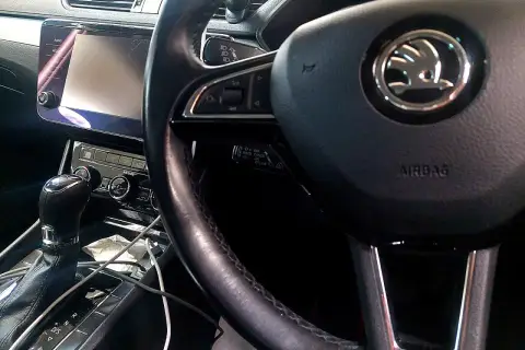 Wnętrze samochodu ze skrzynią biegów, kierownicą i ekranem. Warto sprawdzić poziom oleju do automatycznej skrzyni biegów.
