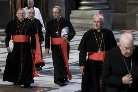 Kardynałowie w czarnych szatach z czerwonymi pasami idą w procesji. To ważny moment, zbliża się wybór papieża.