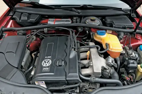 Silnik 1.8t Volkswagena z widocznym logo i oznaczeniem 20V TURBO. Widać elementy układu chłodzenia i dolot powietrza.